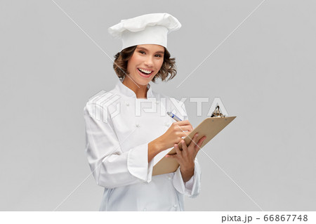 smiling female chef in toque with clipboard smiling female chef in toque with clipboard 66867748