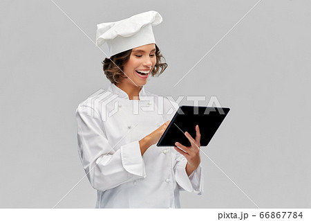 smiling female chef in toque with tablet computer smiling female chef in toque with tablet computer 66867784