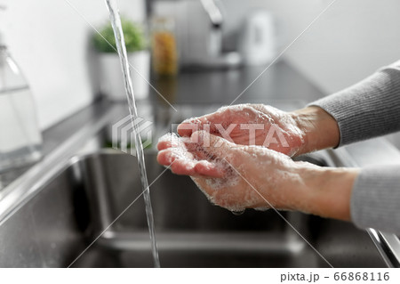 woman washing hands with liquid soap in kitchen 66868116