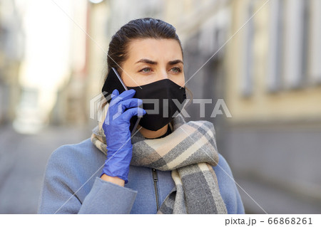woman in protective reusable mask calling on phone woman in protective reusable mask calling on phone 66868261