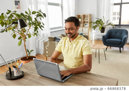 indian man with laptop working at home office 66868378