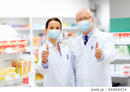 apothecaries in masks show thumbs up at pharmacy apothecaries in masks show thumbs up at pharmacy 66868454