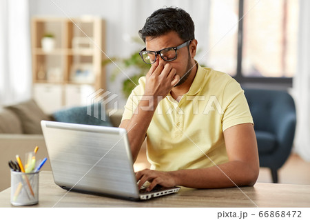 tired man with laptop working at home office 66868472