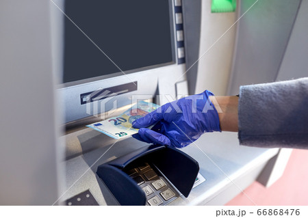 hand in medical glove with money at atm machine hand in medical glove with money at atm machine 66868476