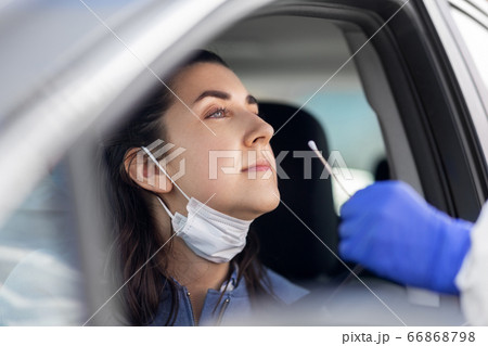 healthcare worker making coronavirus test at car 66868798