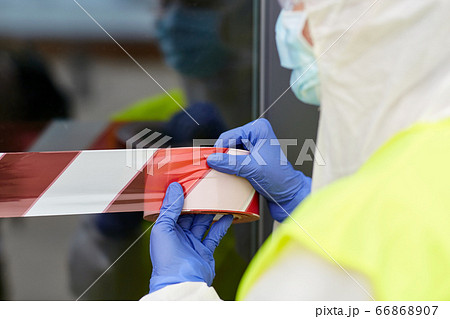 healthcare worker sealing door with caution tape 66868907