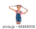Cute small girl smailing and pulling her hair in the air, isolated on white background 66868936