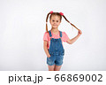 Cute small girl smailing and pulling her hair in the air, isolated on white background 66869002