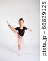 Little girl doing stretching and gymnastic exercises on a white background. 66869125