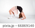 Little girl doing stretching and gymnastic exercises on a white background. 66869140