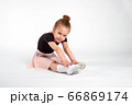 Little girl doing stretching and gymnastic exercises on a white background. 66869174