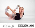 Little girl doing stretching and gymnastic exercises on a white background. 66869199