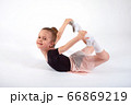 Little girl doing stretching and gymnastic exercises on a white background. 66869219