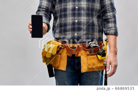 worker or builder with phone and working tools 66869535