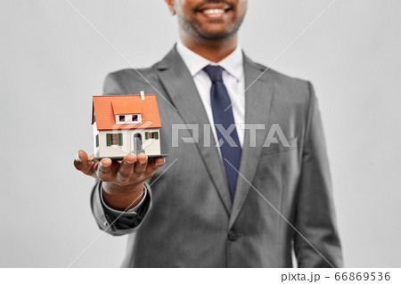 close up of indian man realtor with house model 66869536
