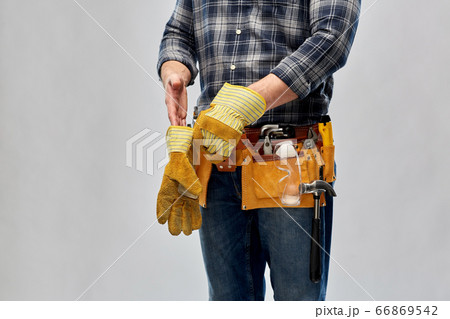 builder with working tools putting gloves on 66869542