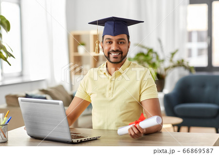 indian student with laptop and diploma at home 66869587