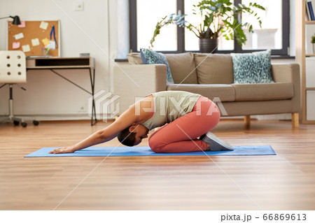 woman doing yoga child's pose at home 66869613