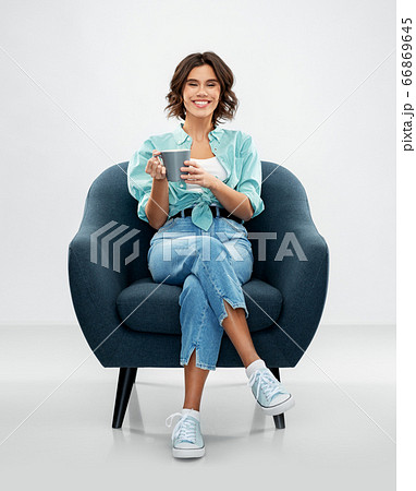 woman sitting in chair with cup of coffee or tea 66869645