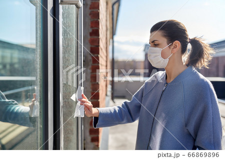 woman in mask cleaning door handle with wet wipe woman in mask cleaning door handle with wet wipe 66869896