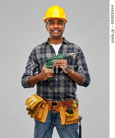 happy indian builder in helmet with electric drill 66869944