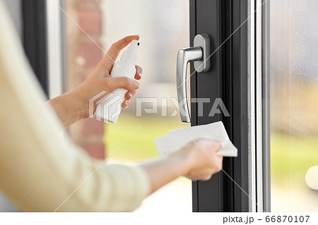 woman cleaning window handle with sanitizer tissue woman cleaning window handle with sanitizer tissue 66870107