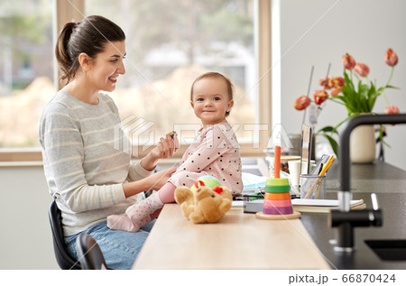 happy mother with baby working at home office 66870424