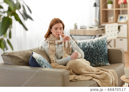 sick woman using nasal spray at home 66870517