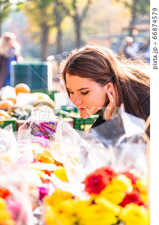Young girl at street flower shop smells bouquet Young girl at street flower shop smells bouquet 66874579