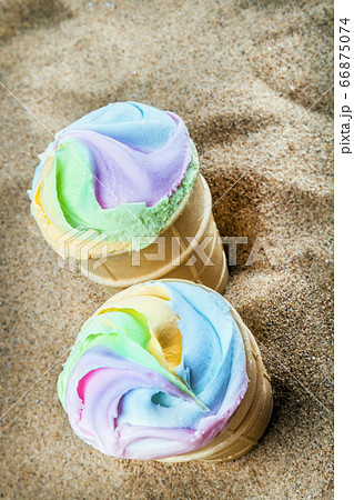 creme brulee ice cream with bright rainbow colors in a waffle Cup on the sand creme brulee ice cream with bright rainbow colors in a waffle Cup on the sand 66875074
