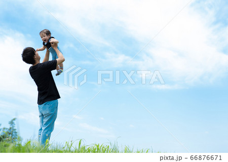 青空の下、赤ちゃんと遊ぶパパ 66876671