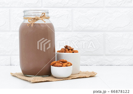 Milk Chocolate and Almonds in a glass on a white background Milk Chocolate and Almonds in a glass on a white background 66878122