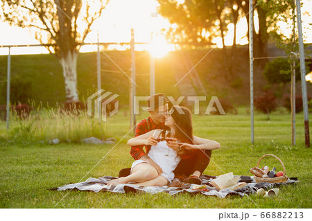 Caucasian young and happy couple enjoying a picnic in the park on summer day 66882213