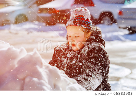 Girl child playing with snow in winter. 66883903