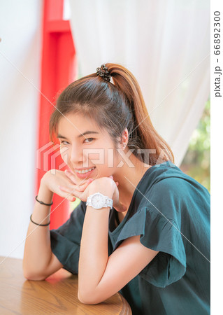 Happy chinese asian woman sitting in a coffee shop 66892300