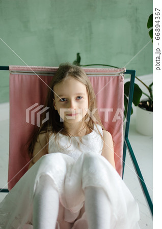 Cute kid girl 5-7 year old sitting on chair in room. Birthday celebration. Party. Cute kid girl 5-7 year old sitting on chair in room. Birthday celebration. Party. 66894367