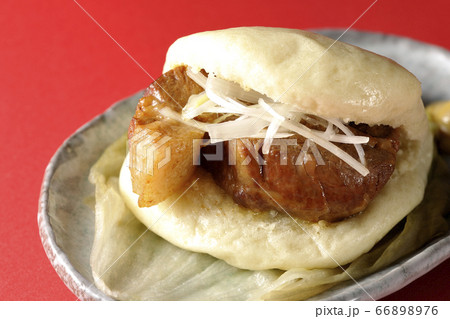 レタスが敷いてあるお皿に置かれた白髪ねぎも一緒に挟まったシンプルな角煮まんと和がらし レタスが敷いてあるお皿に置かれた白髪ねぎも一緒に挟まったシンプルな角煮まんと和がらし 66898976