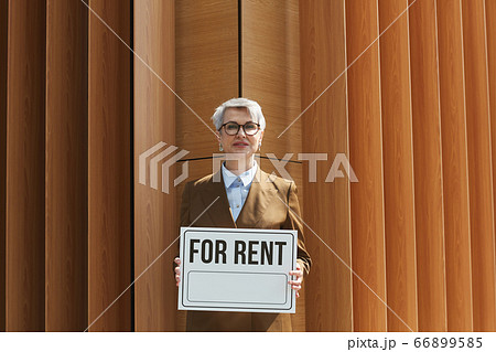 Real estate agent with placard outdoors Real estate agent with placard outdoors 66899585