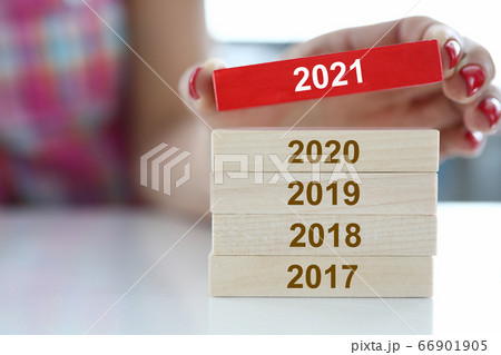 Female hand hold red wooden block with 2021 sign closeup 66901905