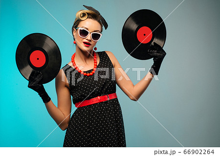 A photo of glamorous pin-up girl holding vinyl LP A photo of glamorous pin-up girl holding vinyl LP 66902264