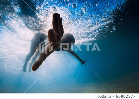 Woman dive without surfboard under ocean wave. Underwater duck dive under wave and sandy bottom Woman dive without surfboard under ocean wave. Underwater duck dive under wave and sandy bottom 66902577