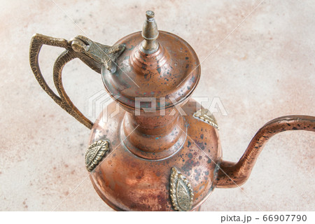 Antique copper jug with lid on concret background. Antique copper jug with lid on concret background. 66907790