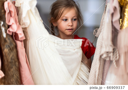 Little girl trying on a new dress Little girl trying on a new dress 66909337