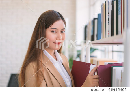 Business woman Searching files and and reading book in the cabinet or books shelves. 66916405