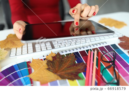 Female hand hold tablet pc against office table background closeup 66918579