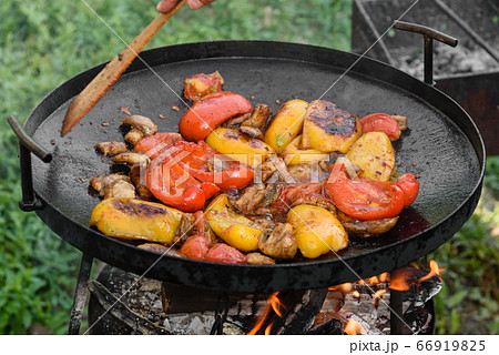 Fresh vegetables are cooked in a grill pan on open 66919825
