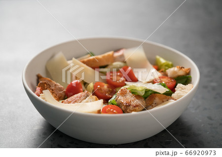 Fresh caesar salad with chicken and cherry tomatoes in white bowl Fresh caesar salad with chicken and cherry tomatoes in white bowl 66920973