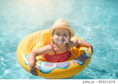 Child In Swimming Pool with ring. Summer Vacation With Kids. Child In Swimming Pool with ring. Summer Vacation With Kids. 66921629