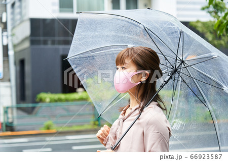 時差出勤　雨天　マスクをして傘をさすビジネスウーマン　出勤　通勤　外出　 66923587