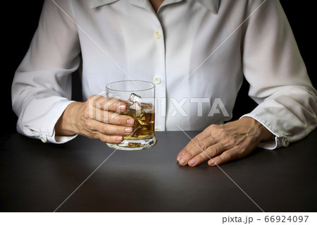 close-up of a woman's hands with a glass of Scotch 66924097